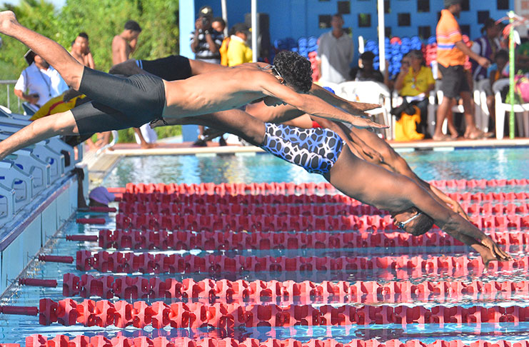 Swimmer's hand reaching forward underwater toward the pool wall